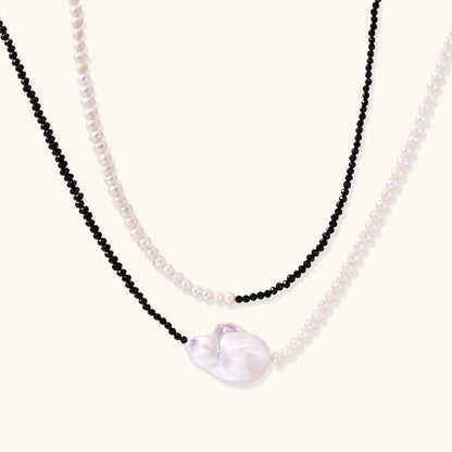 Double-strand necklace with black faceted quartz and white pearls featuring an oversized baroque pearl centerpiece