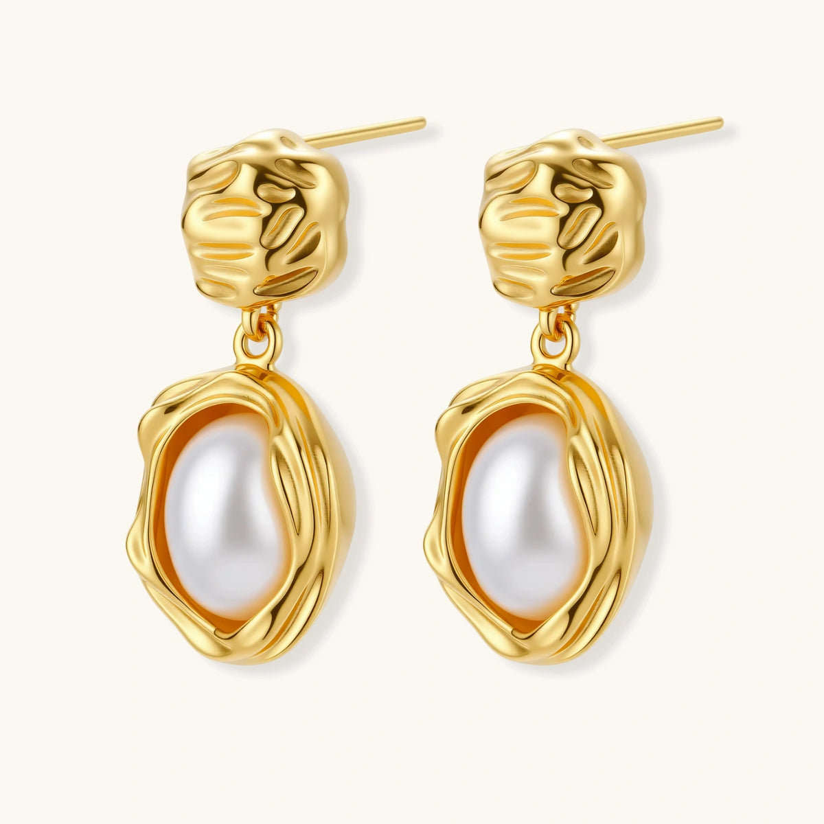 Gold-plated textured stud earrings with white freshwater pearl drops against cream background, showing organic rippled design