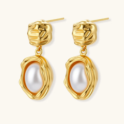 Gold-plated textured stud earrings with white freshwater pearl drops against cream background, showing organic rippled design